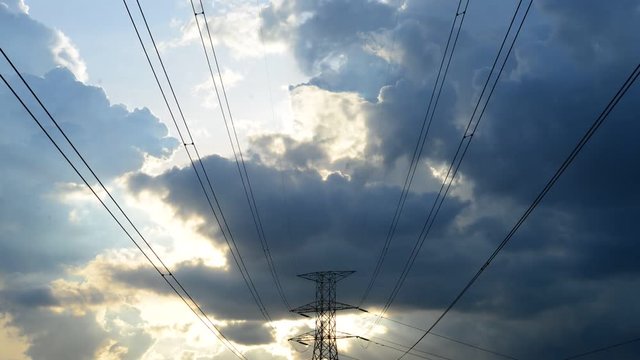 Sunset time lapse with high voltage electricity pole