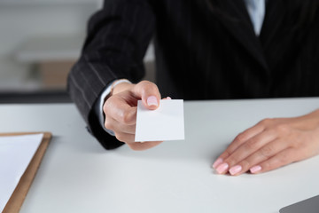 Portrait of young business woman holding blank white business card
