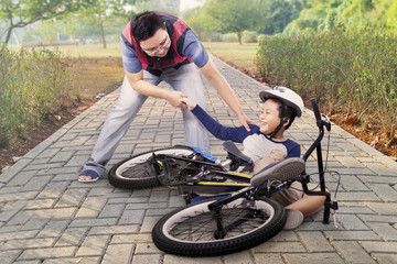 Fototapeta premium Child gets crash and helped by dad