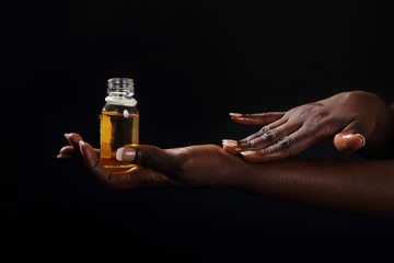 mains femme noire s'enduisant d'huile de baobab