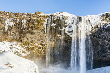 Fototapeta na wymiar Waterfall Seljalandsfoss in winter, reflection in river. Iceland.