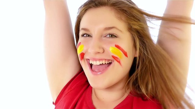 Girl with Spanish flag on her face smiling, slow motion