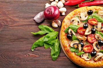 Delicious tasty pizza with ingredients on wooden table