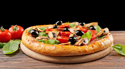 Delicious tasty pizza with ingredients on wooden table