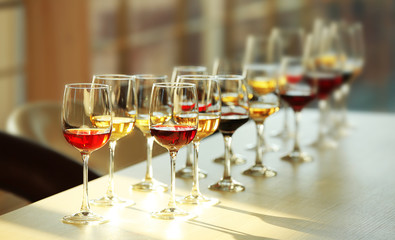 Many glasses of different wine in a row on a table