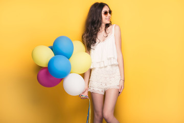 Teenage girl with colorful balloons, studio shot.