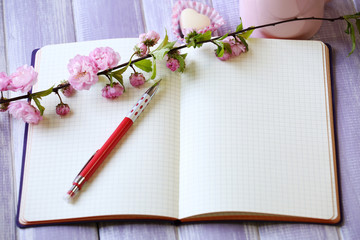 Naklejka premium Cup of fresh coffee and notebook on wooden background