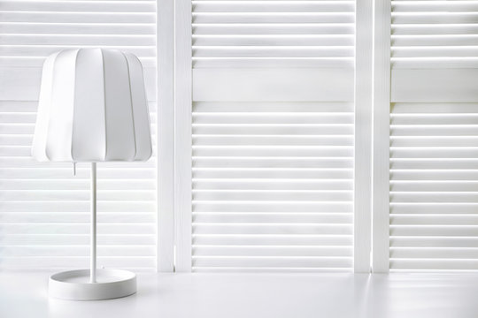 Stylish lamp on white folding screen background