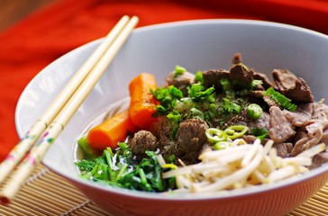 Noodle soup with pork and vegetables in white bowl and chopsticks. Original thai food, Asian food.