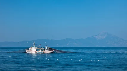 Fishing boat with nests at sea in front of mountain Athos, Greece © banepetkovic