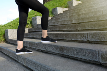 Fototapeta na wymiar Sporty woman running up on stone stairs