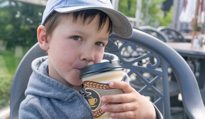 kid boy pretends to drink coffee