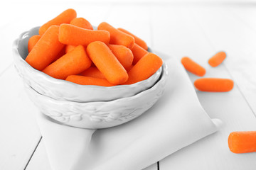 Small baby carrots in soup plates on napkin