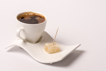 White cup of coffee with turkish delight over white background w