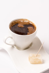 White cup of coffee with turkish delight over white background w