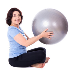 Fototapeta premium portrait of happy mature woman doing exercises with fitness ball