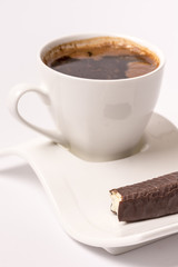 White cup of coffee with chocolate cookie and copy space