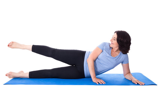 Happy Mature Woman Doing Exercises On Yoga Mat Isolated On White