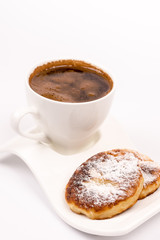 Cup of coffee with homemade donuts with powdered sugar