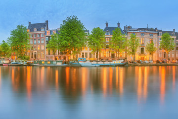 Fototapeta na wymiar Panoramic view and cityscape of Amsterdam with boats, old buildings and Amstel river, Holland, Netherlands