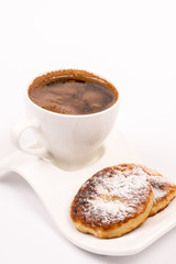 Cup of coffee with homemade donuts with powdered sugar
