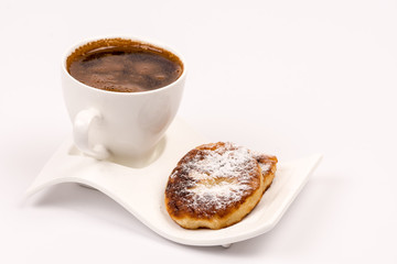 Cup of coffee with homemade donuts with powdered sugar