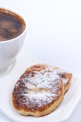 Cup of coffee with homemade donuts with powdered sugar