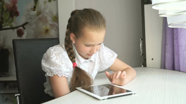 Schoolgirl uses a digital tablet computer at home