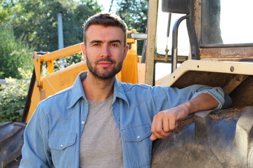 Fototapeta na wymiar Farmer posing in front of his tractor