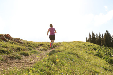 Naklejka na ściany i meble healthy young woman trail runner running on beautiful mountain peak