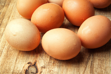 The image of eggs on a wooden table.