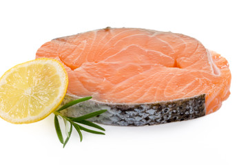 Frisches Lachsfilet, garniert mit einer Scheibe Zitrone und Rosmarin. Auf weissem Hintergrund.