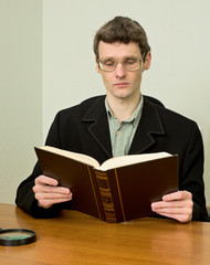 Guy in eyeglasses reads the book