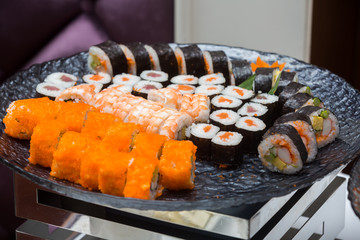 many kind of sushi roll in black plate