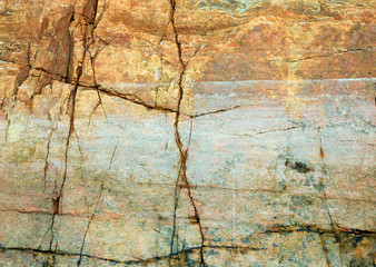 Cracked rock on seacoast backdrop