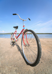 Fototapeta premium Old red bicycle photographed on beach