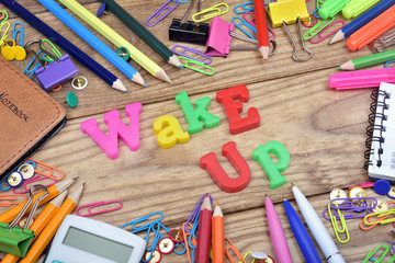 Wake up word and office tools on wooden table