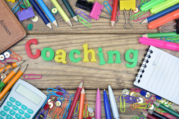 Coaching word and office tools on wooden table