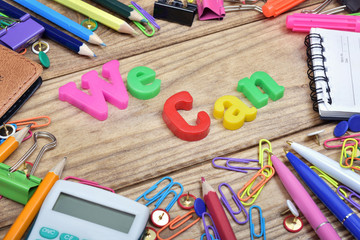 We Can word and office tools on wooden table