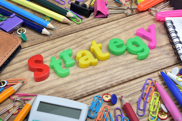 Strategy word and office tools on wooden table