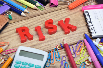 Risk word and office tools on wooden table