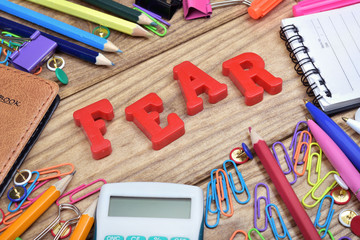 Fear word and office tools on wooden table