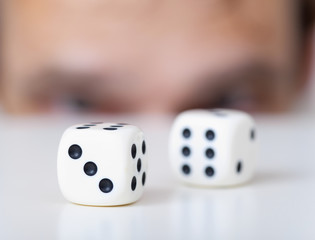 Two playing cubes against man face