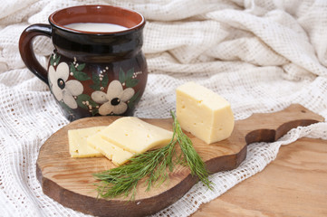 Cheese and dill on the board and a jug of milk