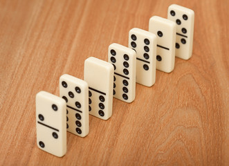 line from seven dominoes on wooden surface