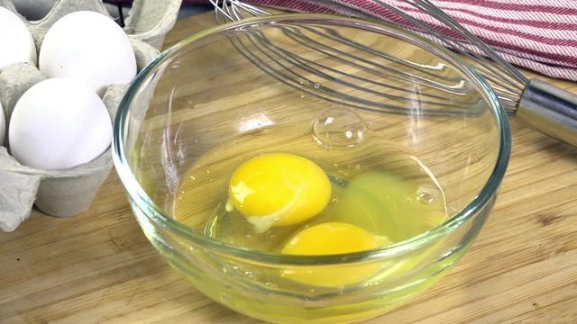 Beating eggs in a glass bowl
