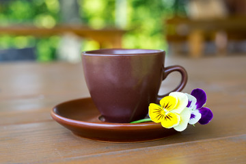 Cup of coffee on wooden table on green background