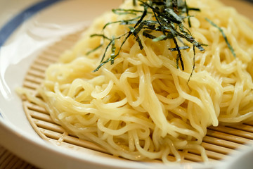 Noodles sprinkled with seaweed on the plate macro closeup