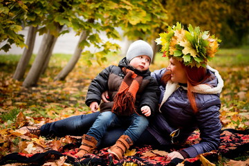 mother and child in autumn forest in warm weather. The concept of motherhood