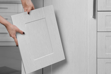 Female hands holding sample of wooden panels for furniture and door